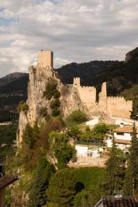 a castle on top of a mountain with trees at La Mocha Casa Rural - La Casa de Ani in La Iruela +20 photos