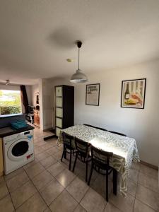 a kitchen and dining room with a table and chairs at Appartement climatisé Résidence Goélia Les Jardins De Phoebus in Gruissan