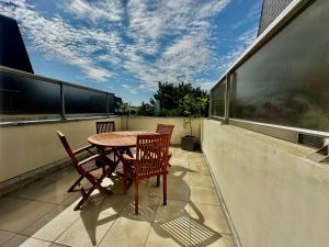 une table et des chaises assises sur un balcon dans l'établissement La mouette rieuse, terrasse, vue mer, accès plage, à Bernières-sur-Mer