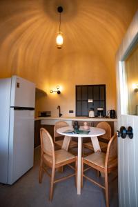 una cucina con tavolo, sedie e frigorifero di Iama Luxury Suite Santorini a Imerovigli