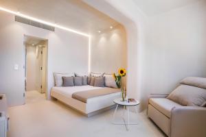 a white living room with a couch and a table at Cocoοns Suites & Villas Fourka in Fourka