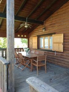 a wooden porch with a wooden table and chairs at Le tre poiane in Terni
