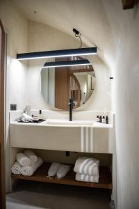 bagno con lavandino, specchio e asciugamani di Iama Luxury Suite Santorini a Imerovigli