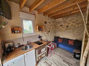 a kitchen with a blue couch in a room at La cabane de Normandie in Nonant