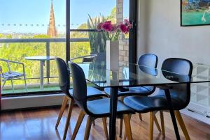 a glass table and chairs with a view of the eiffel tower at Spacious apartment with stunning harbour view in Sydney