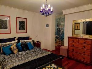 a bedroom with a bed and a dresser and a chandelier at Spacious apartment with stunning harbour view in Sydney +26 photos