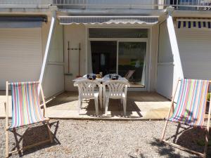Dos sillas y una mesa en un patio. en Studio Cabine,3 couchages, RDC, en Narbonne-Plage