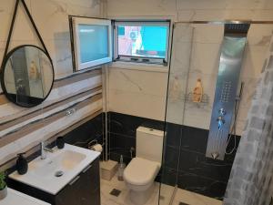 a bathroom with a toilet and a sink and a shower at Joannas Luxury Apartment in Corfu +37 photos