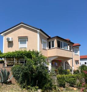 a large house with bushes in front of it at Apartments Ostojic in Krk
