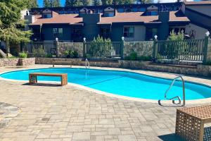 a swimming pool with a bench in front of a house at Chamonix 100 in Mammoth Lakes