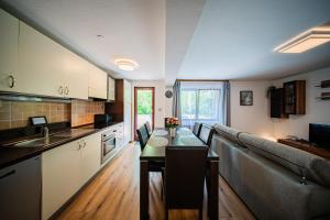 een keuken met een tafel en een bank in een kamer bij Flex SelfCheckIns 159 - Zagreb - 2 Bedrooms - Parking - Terrace in Zagreb