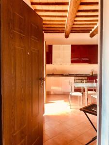a room with a kitchen and a table with chairs at La Fattoria - centro storico in Campagnatico +12 photos