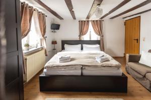 a bedroom with a large bed and a couch at Seminarhaus Heim Retreat, Fachwerkhaus von 1451, Yoga, Naturgarten für 10 Personen in Ellenz-Poltersdorf
