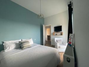 Un dormitorio con una cama blanca y una silla. en Stefanos by Hospi, en Kato Gouves