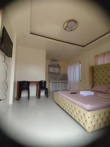 a bedroom with a bed and a table and chairs at Sofia's Guest House-Siquijor in Larena