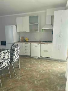 a kitchen with white cabinets and a table and chairs at Spacious Apartment in Kojori in Tbilisi City