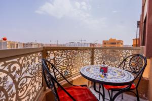 a table and chairs on a balcony with a view at HAGS Apartment - Traditional Modern Apartment, full AC, 10m from airport in Marrakech