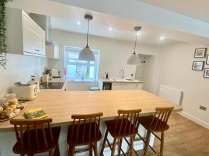 a kitchen with a large wooden table and chairs at Morfarch traditional stone cottage within Conwy walls in Conwy
