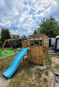 a playground with a slide and a climbing frame at Surf Przyczepa Jastarnia in Jastarnia