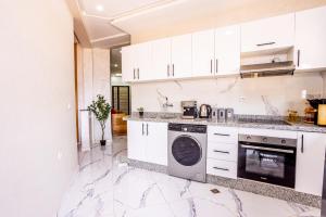 a kitchen with white cabinets and a dishwasher at HAGS Apartment - Traditional Modern Apartment, full AC, 10m from airport in Marrakesh