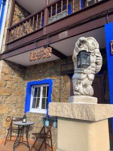 a statue in front of a building with a table at La Casina de Martín in Limanes