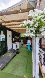 a patio with a table and white flowers at Surf Przyczepa Jastarnia in Jastarnia +6 photos