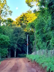 ein Feldweg mit Bäumen und einem Holzzaun in der Unterkunft la escondida in Puerto Leoni