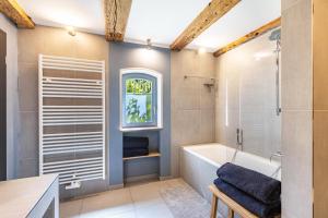 a bathroom with a tub and a sink and a window at Ferienwohnung im Pferdestall in Angermünde