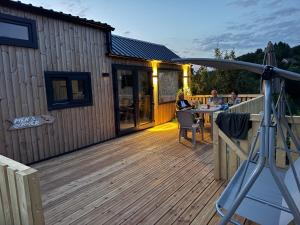 two people sitting at a table on a deck at Baraca lu Max in Cuptoare