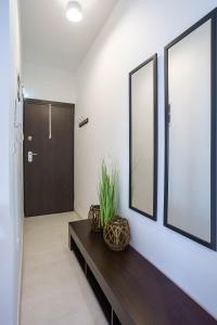 a hallway with a table and two mirrors and a door at Modern Nook in the Centre in Thessaloniki