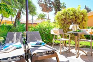 a patio with two chairs and a table with a hat at Maspalomas Villas by Dunas - Adults Only in Maspalomas