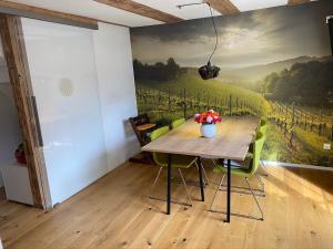 ein Esszimmer mit einem Tisch und einem Gemälde an der Wand in der Unterkunft Traumhaft Wohnen Im Haus Blum in Herbolzheim + 16 Fotos