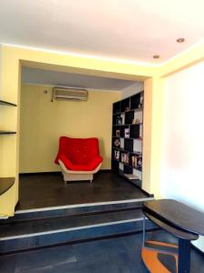 康斯坦察Summer Oasis in Constanta的一张红色椅子坐在带桌子的房间