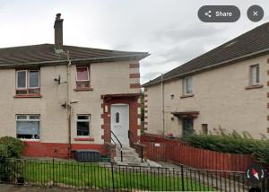 a house with a fence in front of it at Modern 2 Bedroom with extra Loft Bedroom in Glasgow