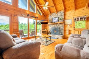 a living room with two couches and a stone fireplace at Change of Attitude By Avada Properties in Sevierville