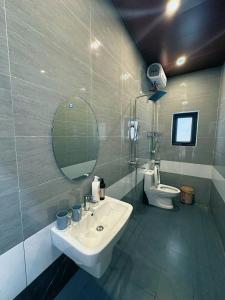 ein Badezimmer mit Waschbecken, Spiegel und Toilette in der Unterkunft Trang an rice field homestay in Ninh Bình