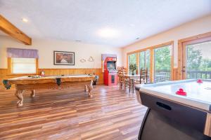 a living room with a pool table and a kitchen at Change of Attitude By Avada Properties in Sevierville