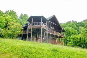 a large house sitting on top of a green hill at Change of Attitude By Avada Properties in Sevierville