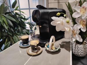 a coffee maker on a counter next to some flowers at Appartement a Millau in Millau +2 photos