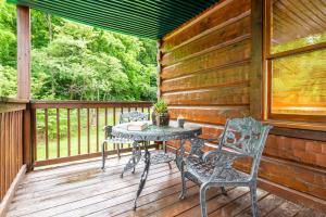 a patio with a table and chairs on a deck at Change of Attitude By Avada Properties in Sevierville