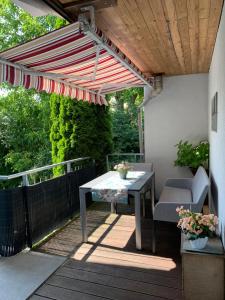 d'une terrasse avec une table et un parasol rouge et blanc. dans l'établissement Haus Seeblick Markdorf, à Markdorf