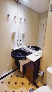 a bathroom with a black sink and a mirror at Flat Hotel Sena Madureira (Apto 1108) in Sao Paulo
