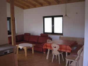 a living room with a red couch and a table at Ferienhof auf dem Berg in Gossersweiler-Stein