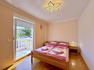 a bedroom with a bed and a large window at Apartments Vodopija in Soline