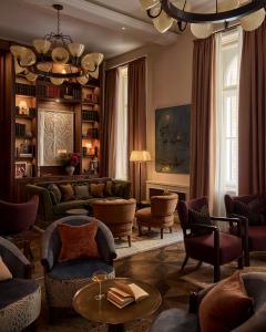 a living room with a couch and chairs and a chandelier at Sir Prague, part of Sircle Collection in Prague