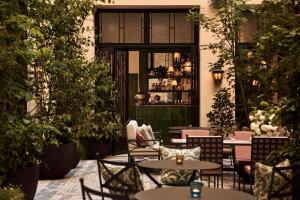 an outdoor patio with tables and chairs and plants at Sir Prague, part of Sircle Collection in Prague