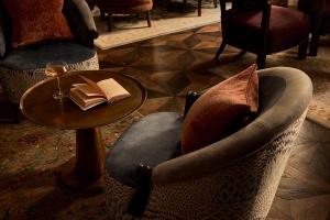 a chair and a table with a glass of wine at Sir Prague, part of Sircle Collection in Prague