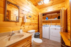 a bathroom with a toilet and a sink in a cabin at Cozy Bear By Avada Properties in Gatlinburg +56 photos