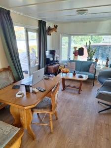a living room with a table with a laptop on it at Cosy 1 bedroom chalet near the woods in Anloo