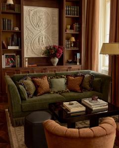 a living room with a green couch and a table at Sir Prague, part of Sircle Collection in Prague